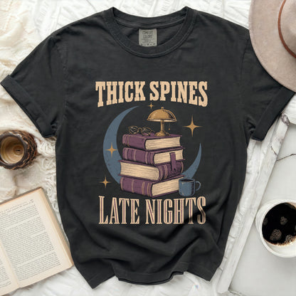 Graphic tee with "Thick Spines Late Nights" text and book stack.