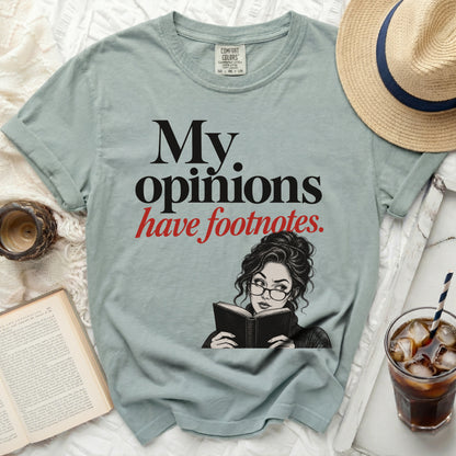 Light blue t-shirt with black text "My opinions have footnotes." and a woman reading.