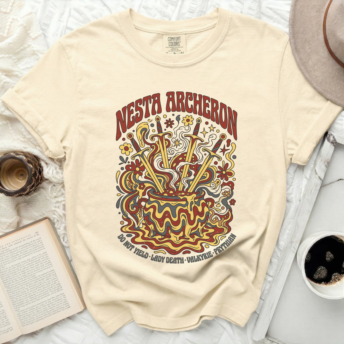 Nesta Archeron graphic tee with swords, flowers, and psychedelic design.