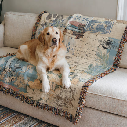 A golden retriever dog is lying on a couch with a decorative blanket featuring floral and nature-inspired designs.
