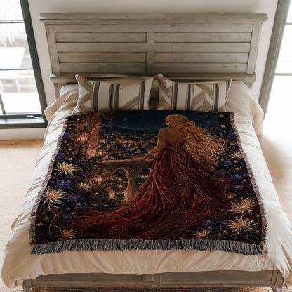 a large bed with a decorative blanket that depicts a woman in a flowing red dress standing in front of a cityscape at night.