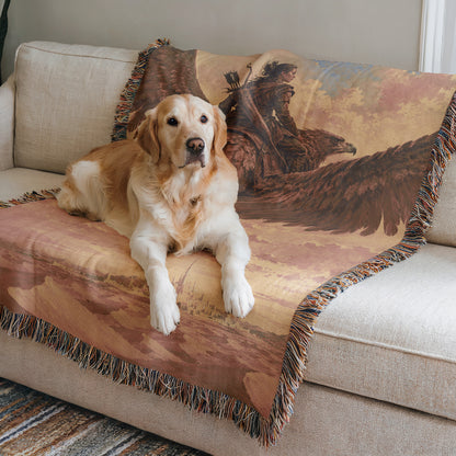 A golden retriever dog is sitting on a couch, resting its head on a decorative blanket with a painting of a Native American buffalo.