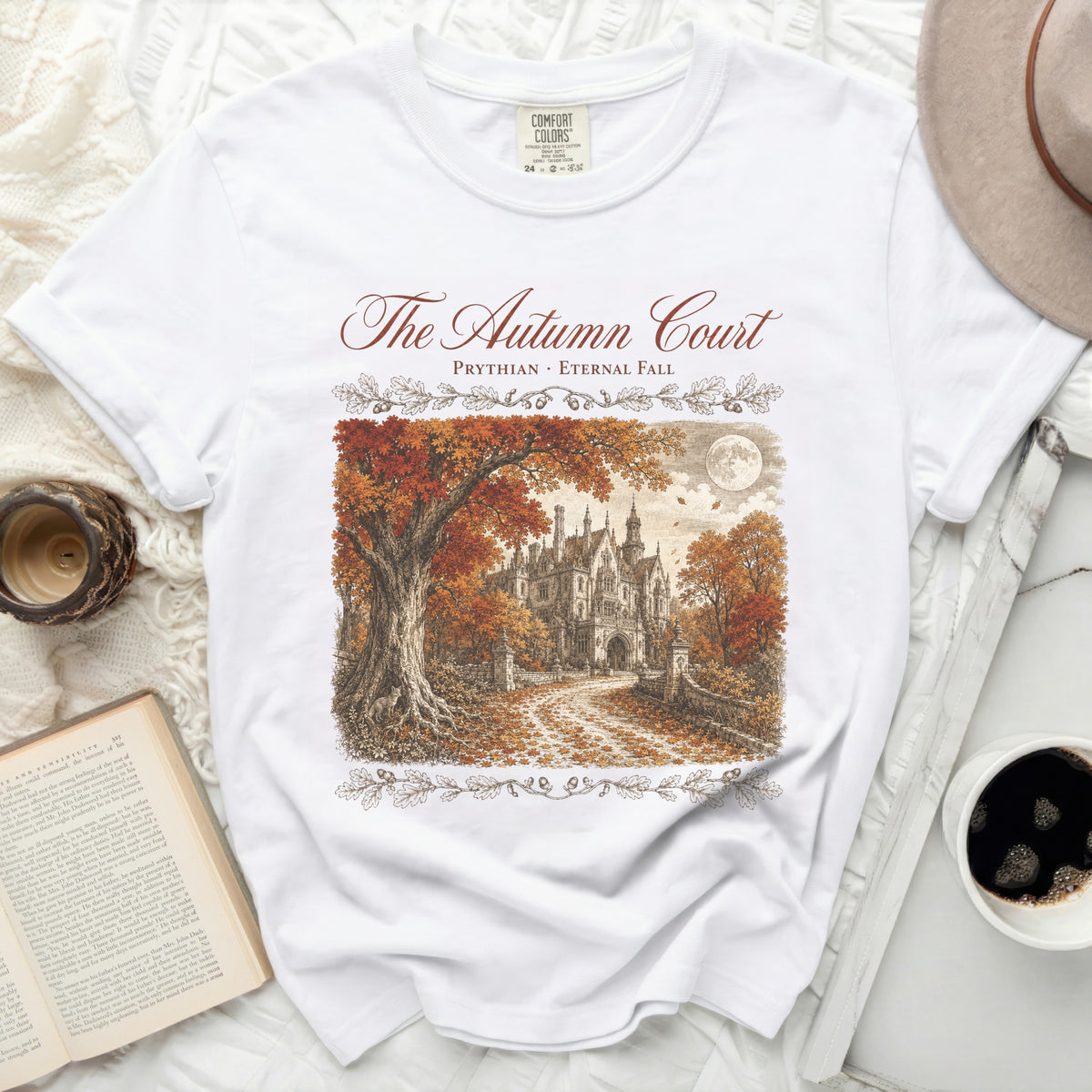 White t-shirt with "The Autumn Court" and a drawing of a gothic mansion in autumn.