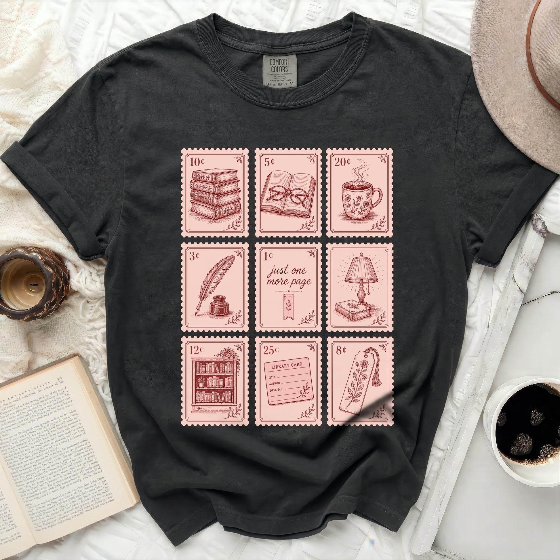 Black t-shirt with nine square illustrations of books and stationery.