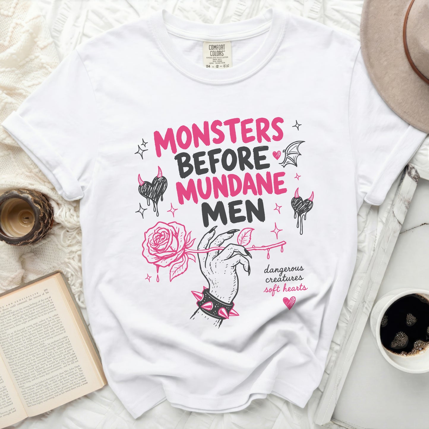 White t-shirt with "Monsters Before Mundane Men" text and rose design.