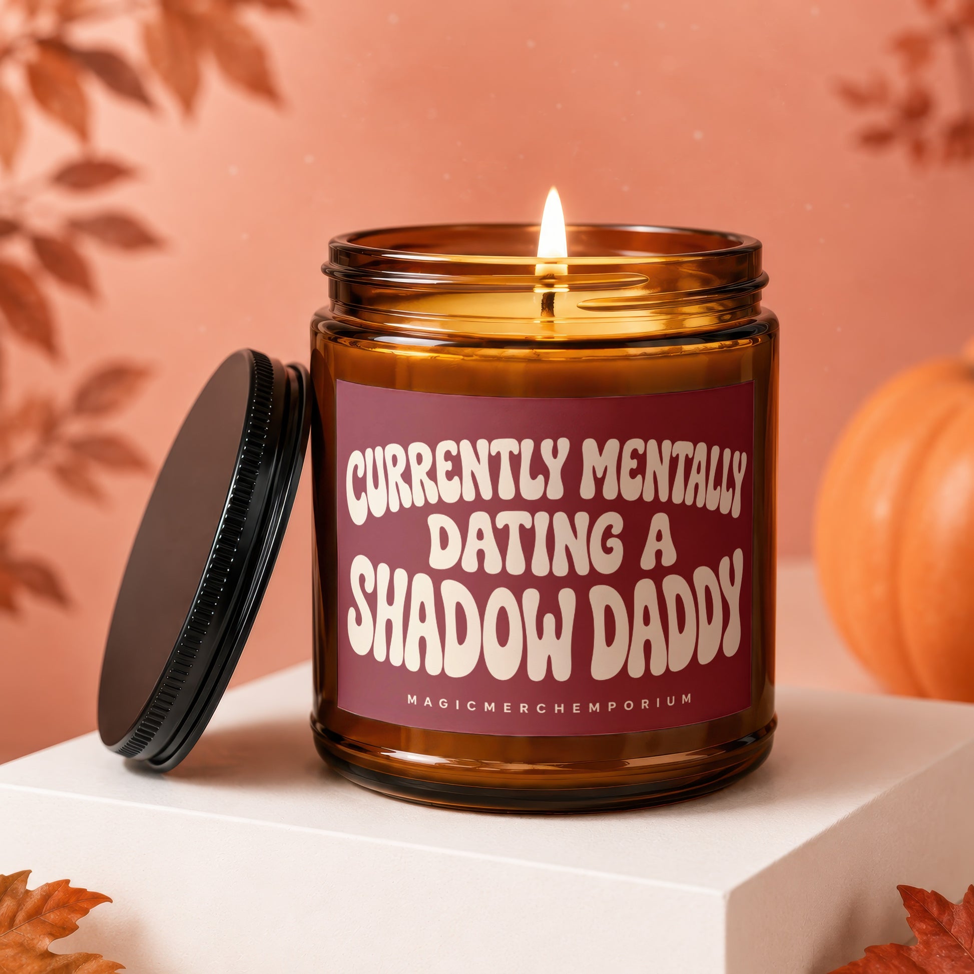 Amber candle with a lit wick, maroon label reading "Currently Mentally Dating a Shadow Daddy".
