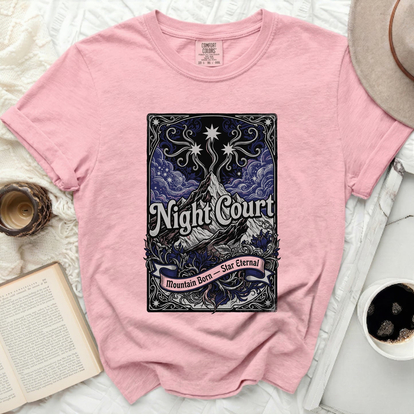Pink t-shirt with "Night Court Mountain Born Star Eternal" graphic.