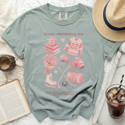 T-shirt with hockey, book, and coffee graphics, text "Pucks, Promises & You".