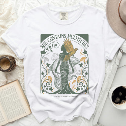 White t-shirt with "She Contains Multitudes" and mythical creatures design.