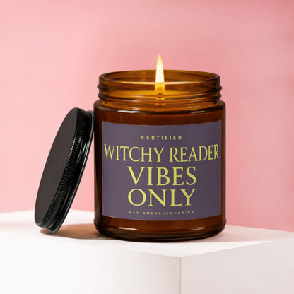 Amber candle with lit flame, featuring a purple label with yellow text.