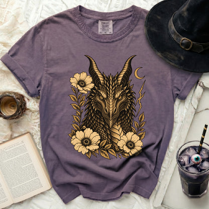 Purple t-shirt with a gold dragon head design surrounded by flowers.