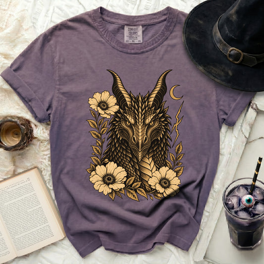 Purple t-shirt with a gold dragon head design surrounded by flowers.