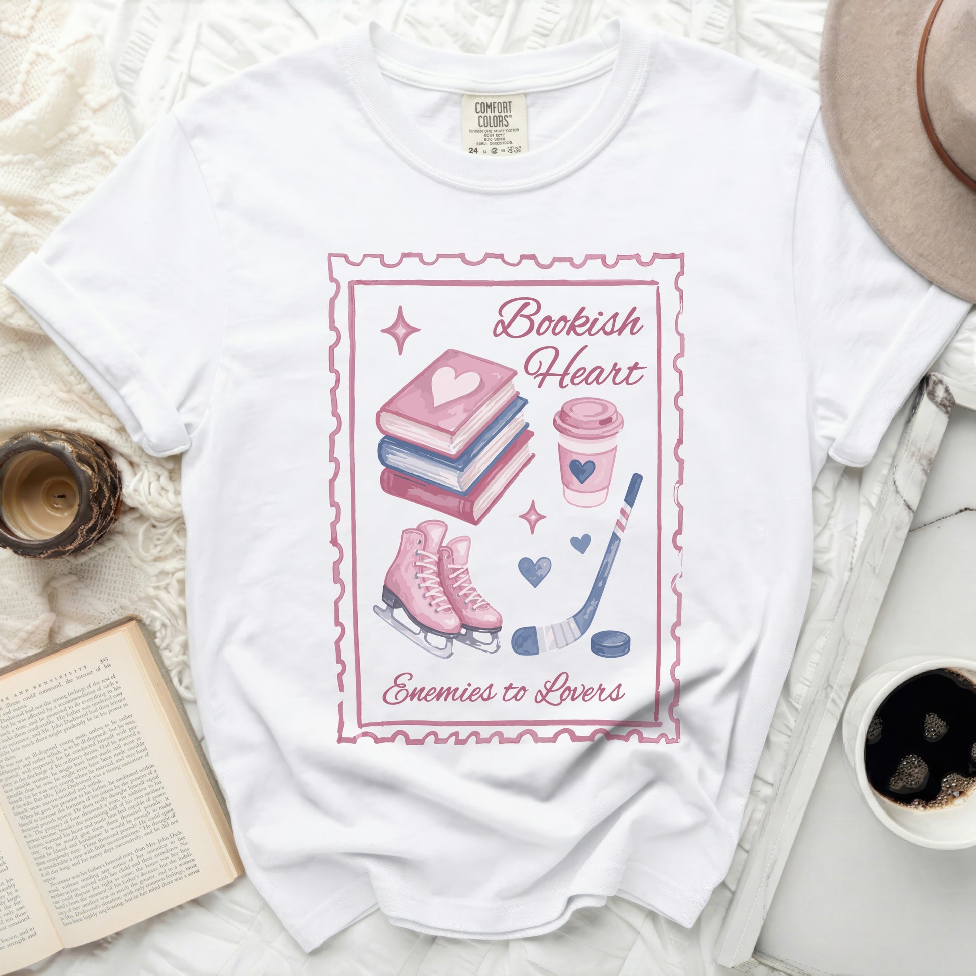 White t-shirt with "Bookish Heart Enemies to Lovers" graphic featuring books, skates, and coffee.