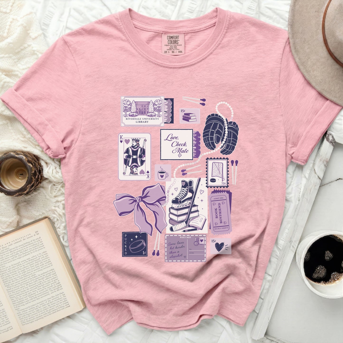 Pink t-shirt with hockey-themed collage: book, deck of cards, matches, skates.