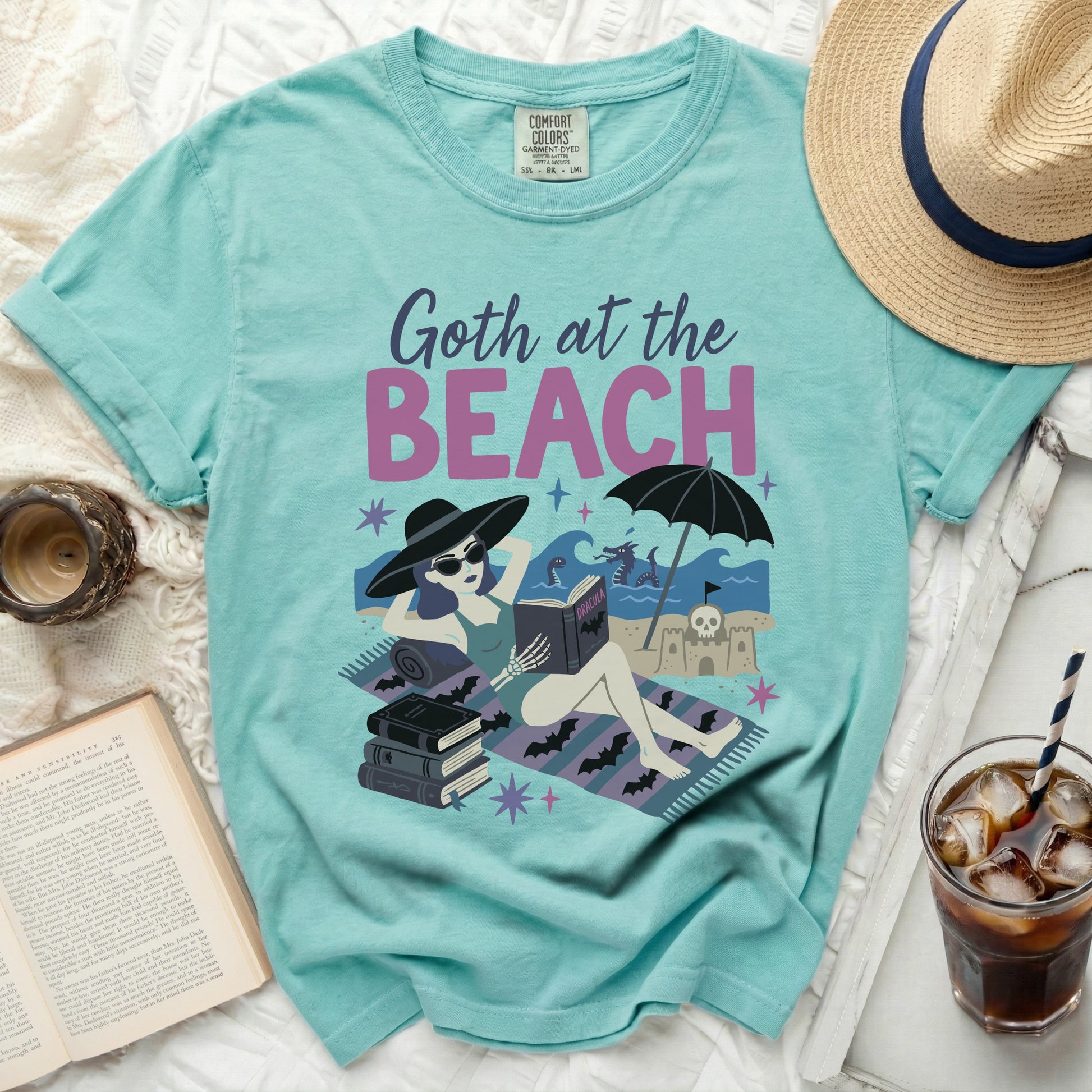 Comfort Colors t-shirt with "Goth at the Beach" and Dracula reading by the sea.