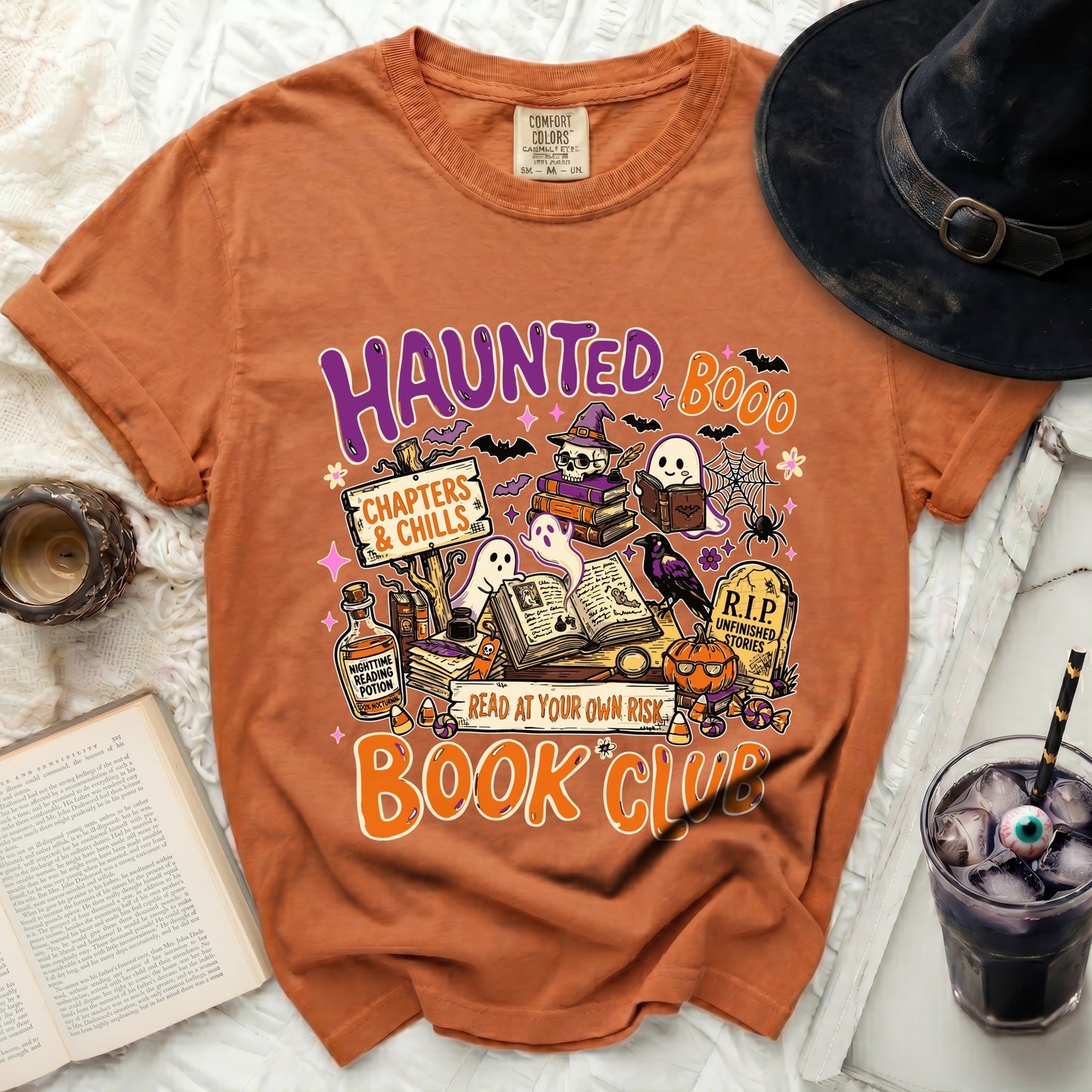 Orange t-shirt graphic with "Haunted Book Club" text and Halloween-themed illustrations.