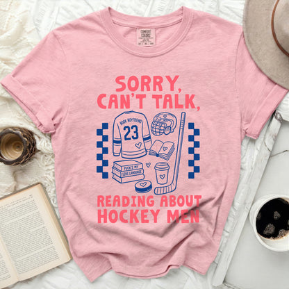 Pink t-shirt with "Sorry, Can't Talk, Reading About Hockey Men" and hockey graphics.