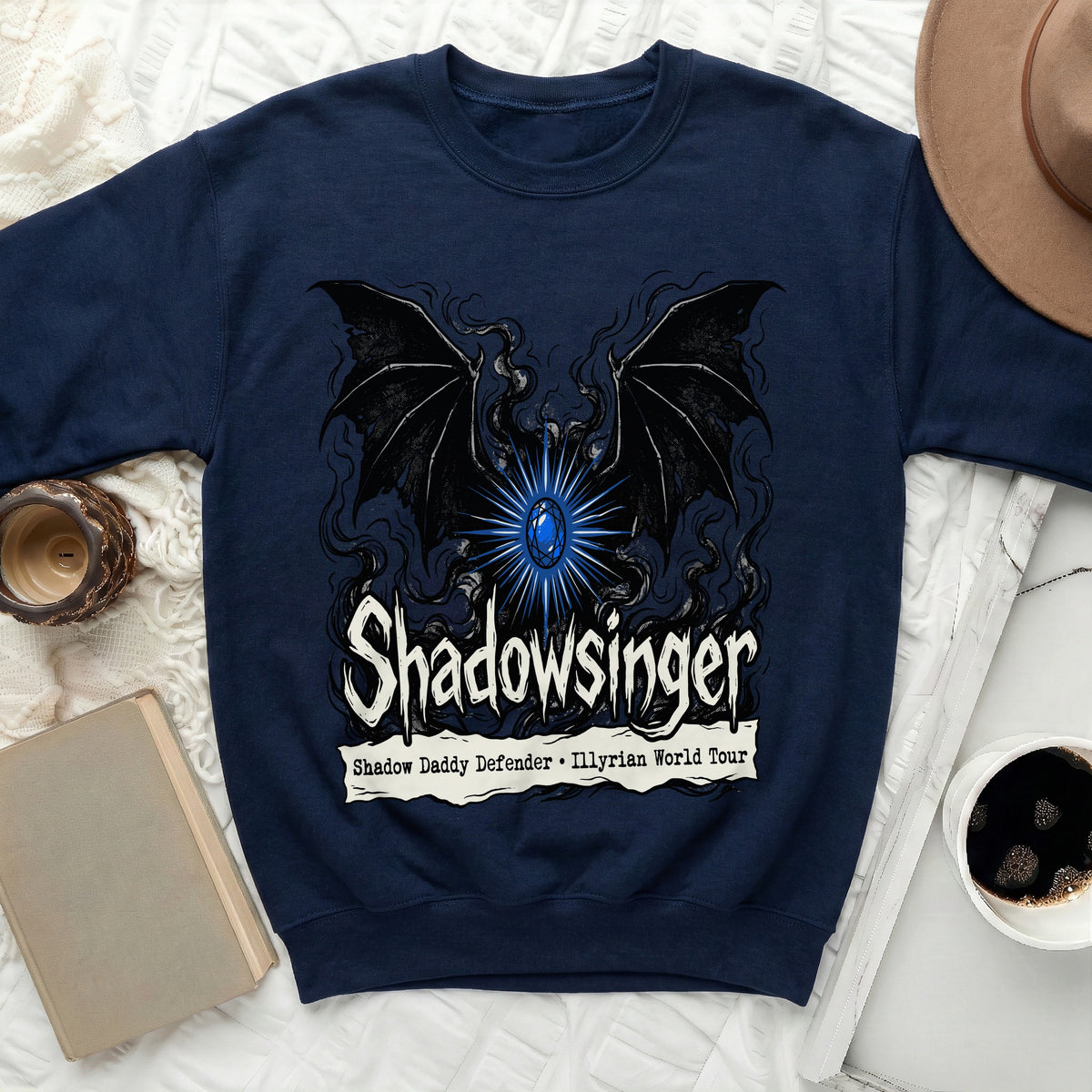 Navy blue crewneck sweatshirt with a graphic of black bat wings, blue glowing gem, and Shadowsinger text.
