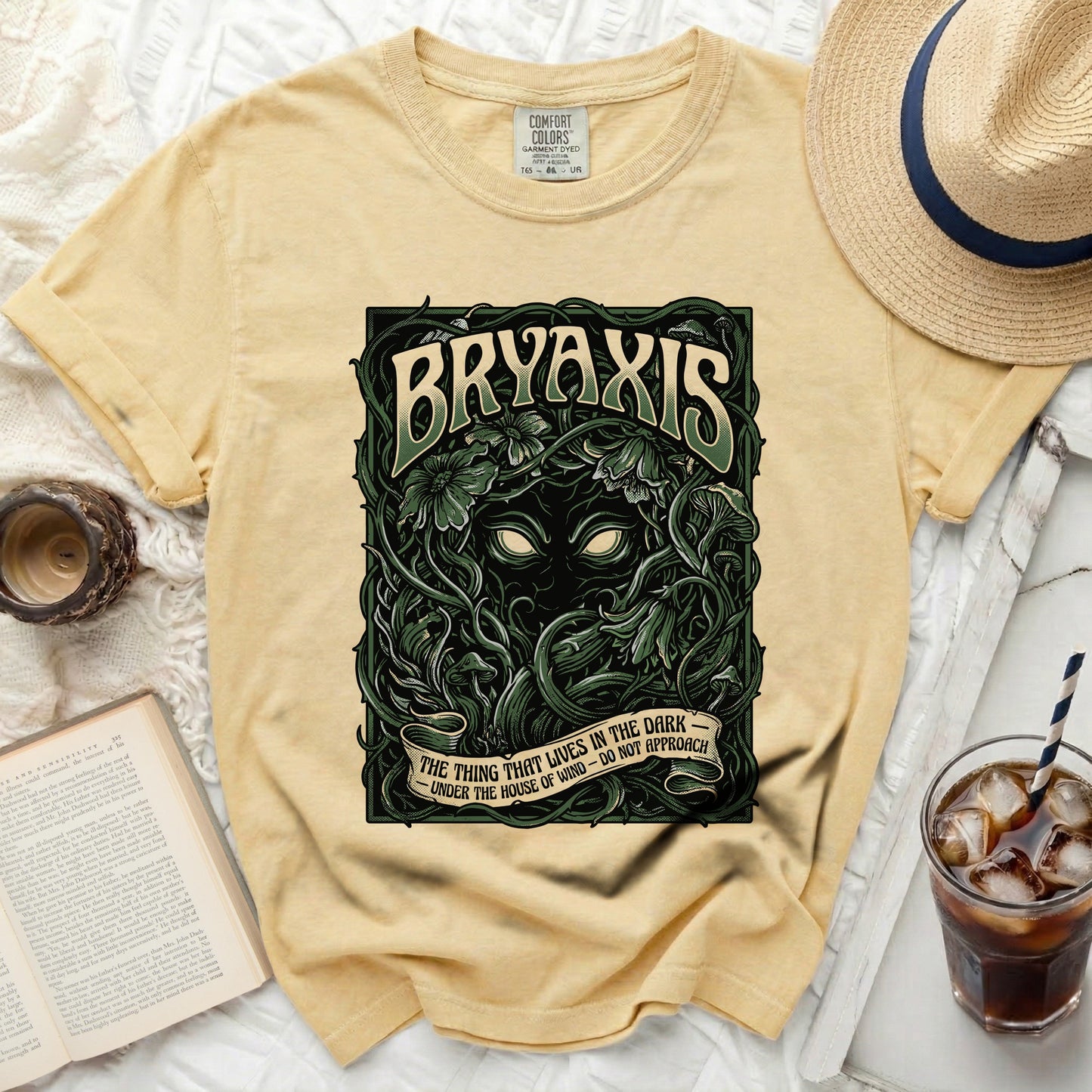 Yellow t-shirt with "BRYAXIS" and "THE THING THAT LIVES IN THE DARK" graphic.