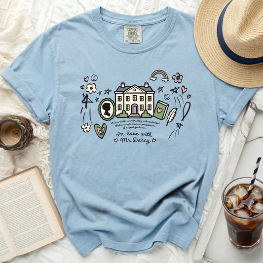 Light blue t-shirt with house, book, quill, cameo, and text reading "In love with Mr. Darcy."