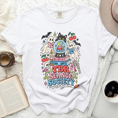 White t-shirt with "TBR Seance Society summoning one more chapter" graphic.