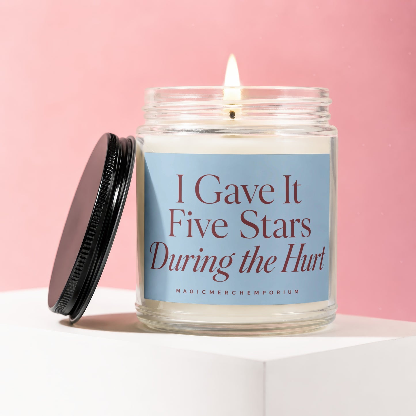 Candle with text "I Gave It Five Stars During the Hurt" on light blue label.