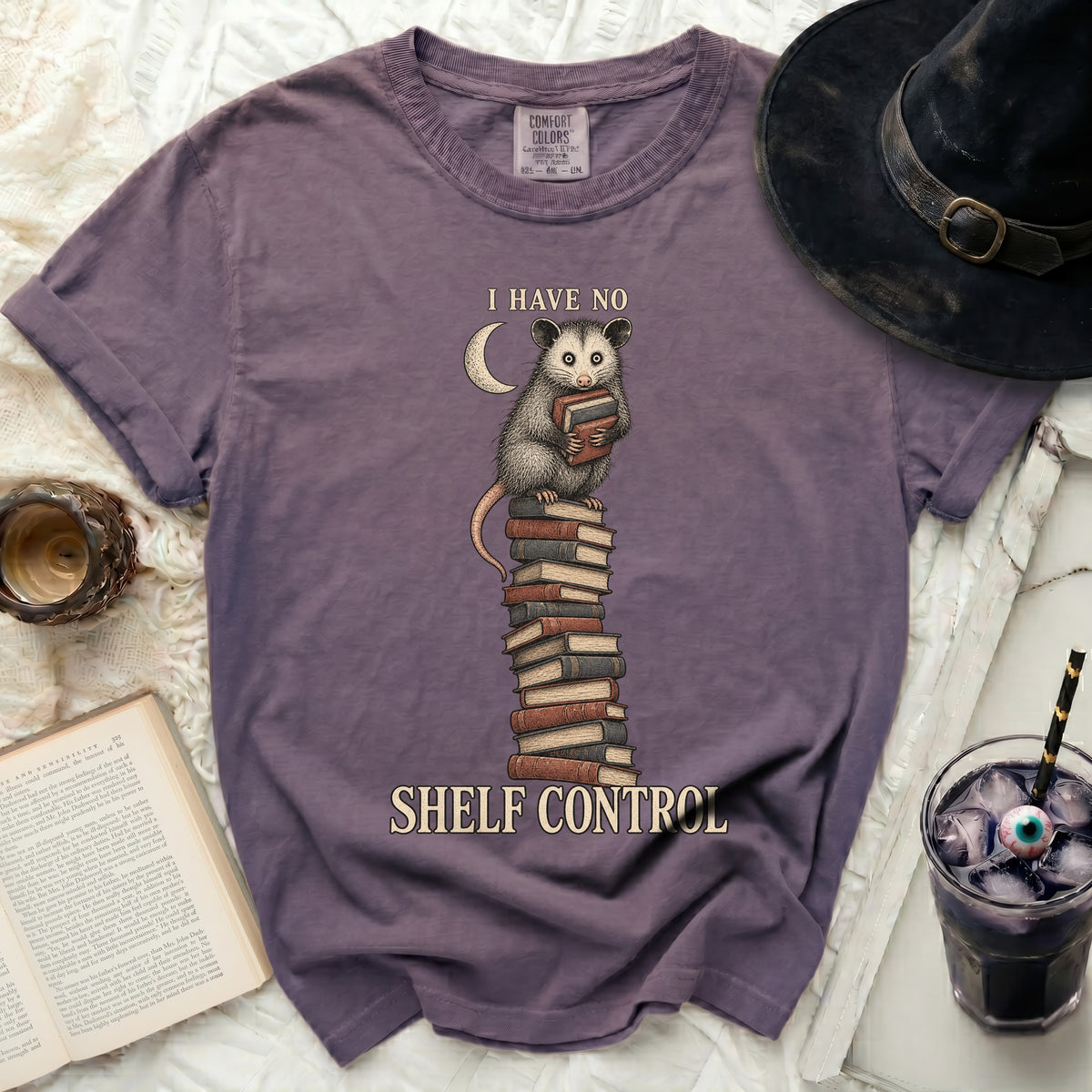 Opossum reading books with text "I HAVE NO SHELF CONTROL"