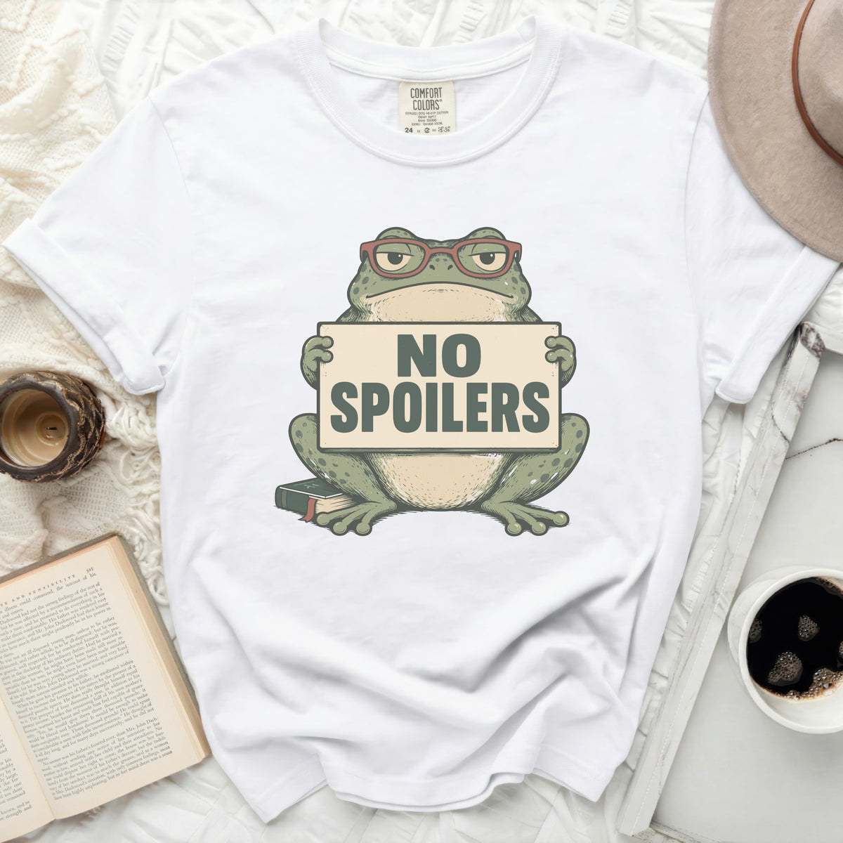 White t-shirt with a green frog wearing glasses holding a sign that says "NO SPOILERS".