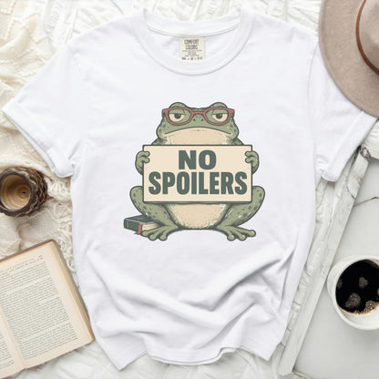 White t-shirt with a green frog wearing glasses holding a sign that says "NO SPOILERS".