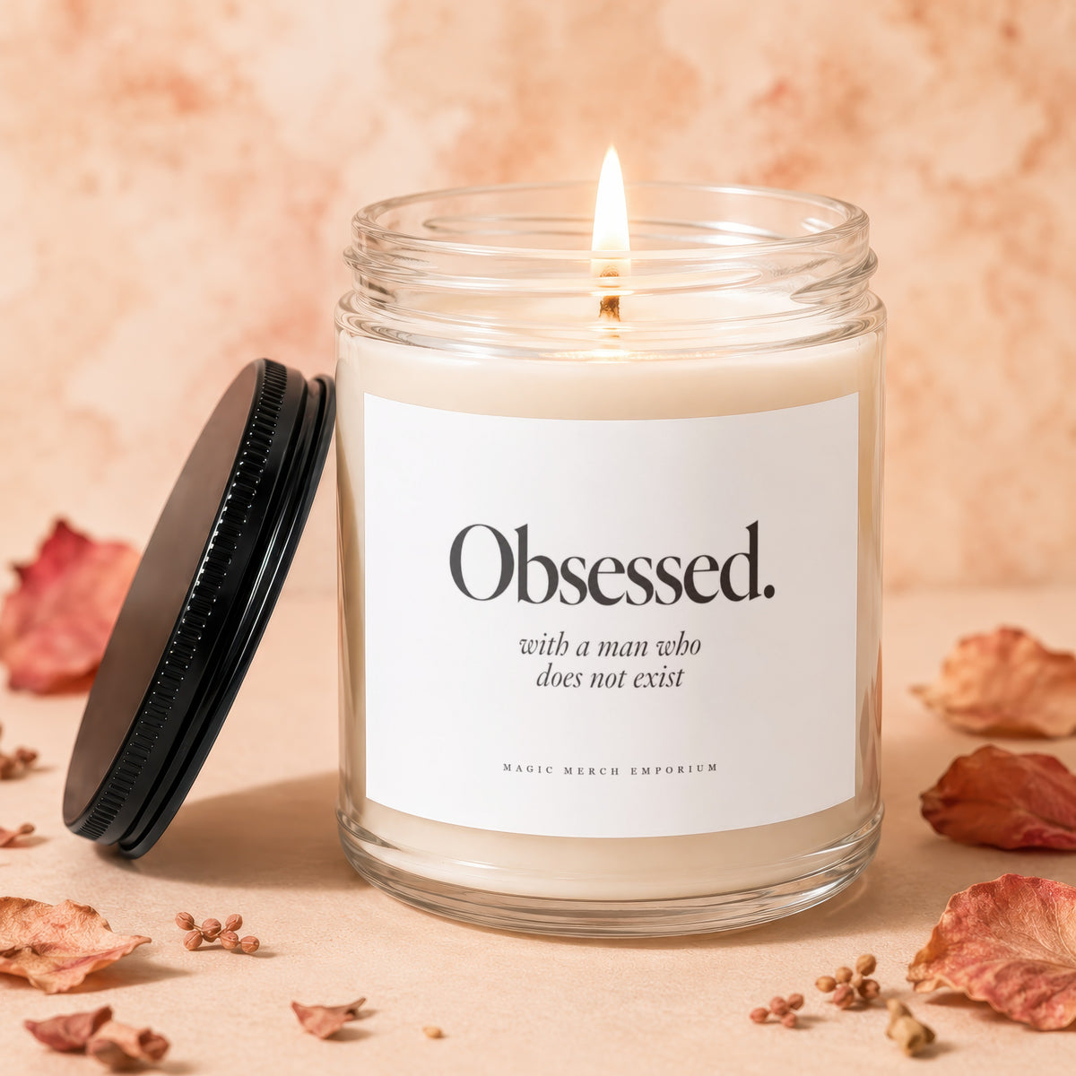 Lit candle in glass jar with "Obsessed. with a man who does not exist" label.