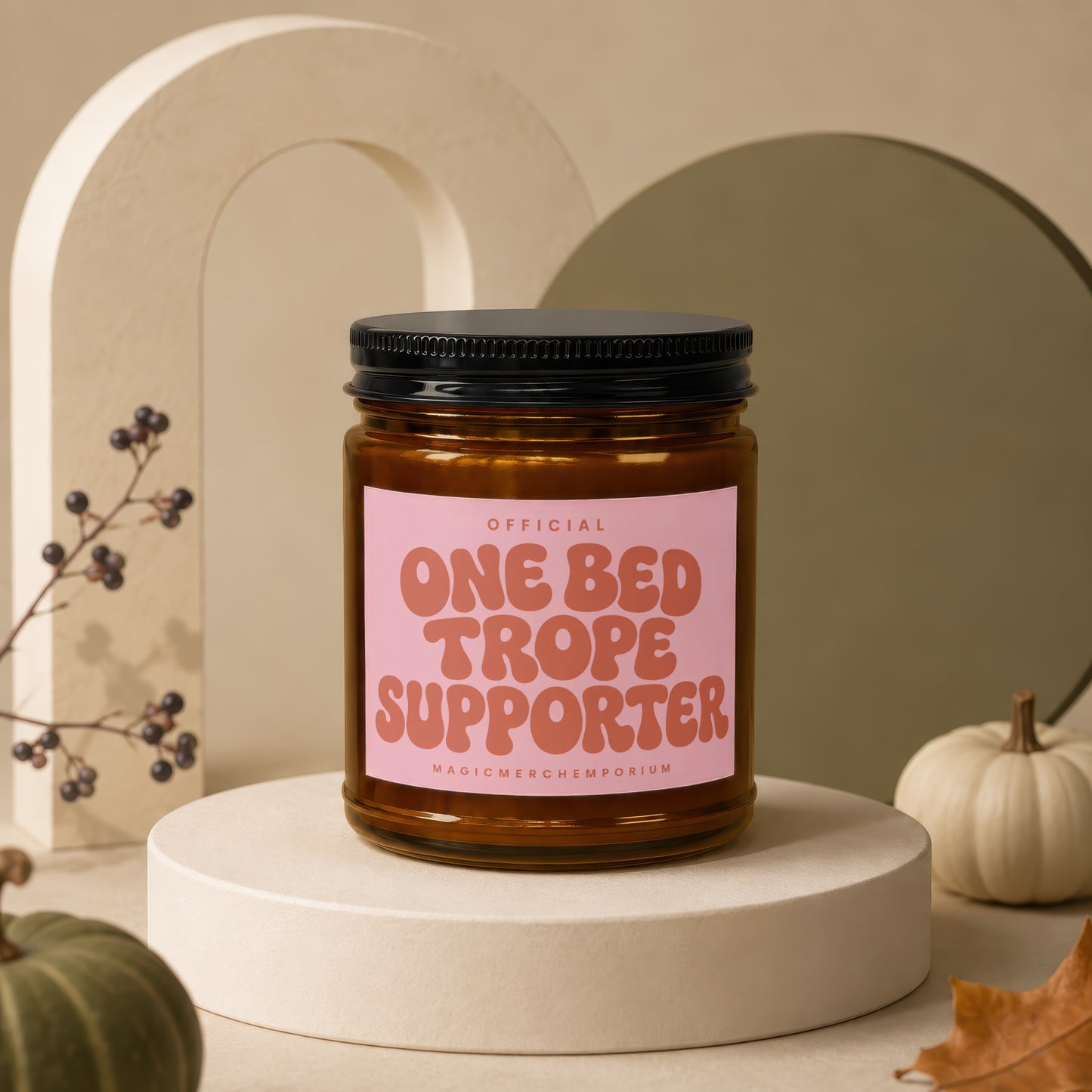 Amber jar candle with black lid labeled "ONE BED TROPE SUPPORTER".