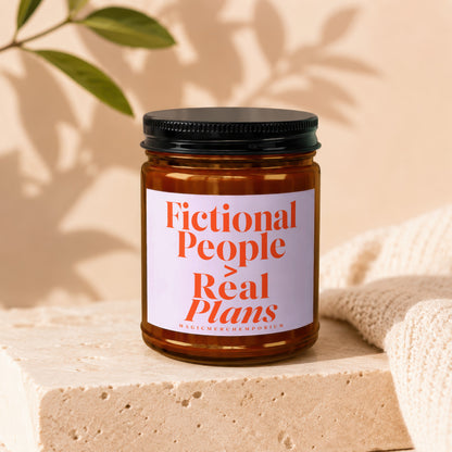Amber jar candle with white label reading "Fictional People Real Plans."