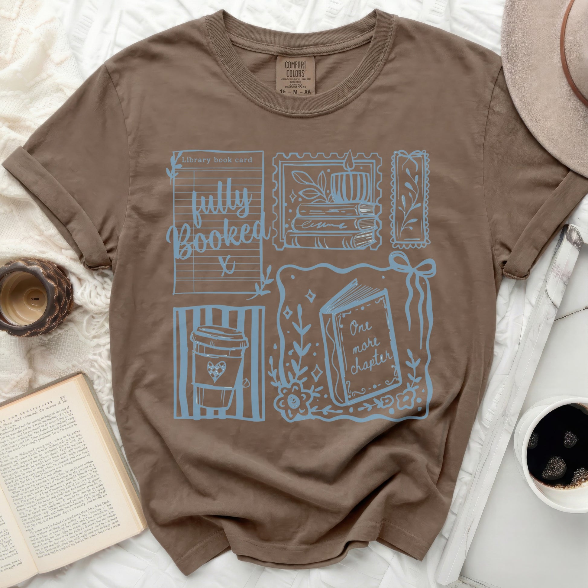 Brown Comfort Colors t-shirt with "fully Booked" and book-themed graphics.