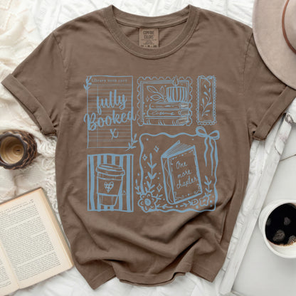 Brown Comfort Colors t-shirt with "fully Booked" and book-themed graphics.