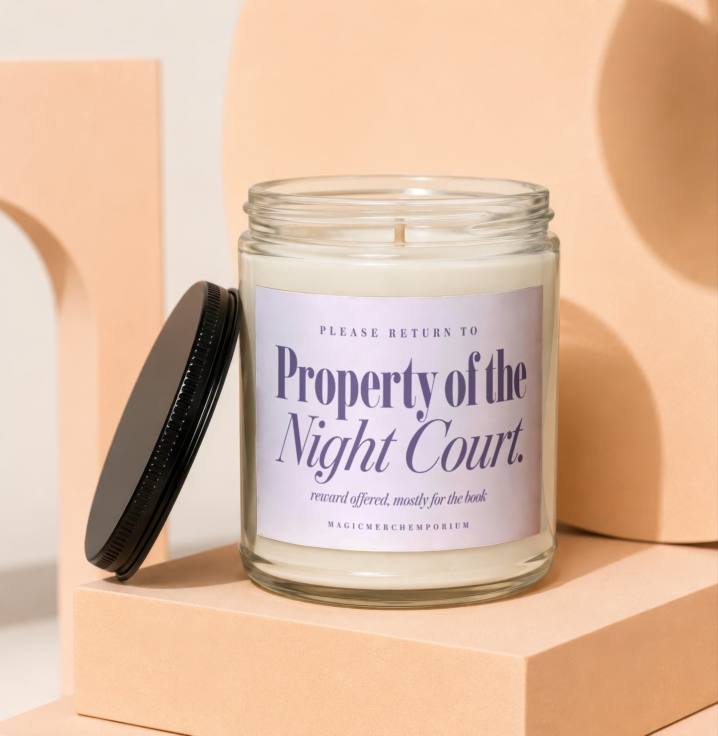 Glass candle with label reading "Property of the Night Court" and "MAGICMERCHEMPORIUM."