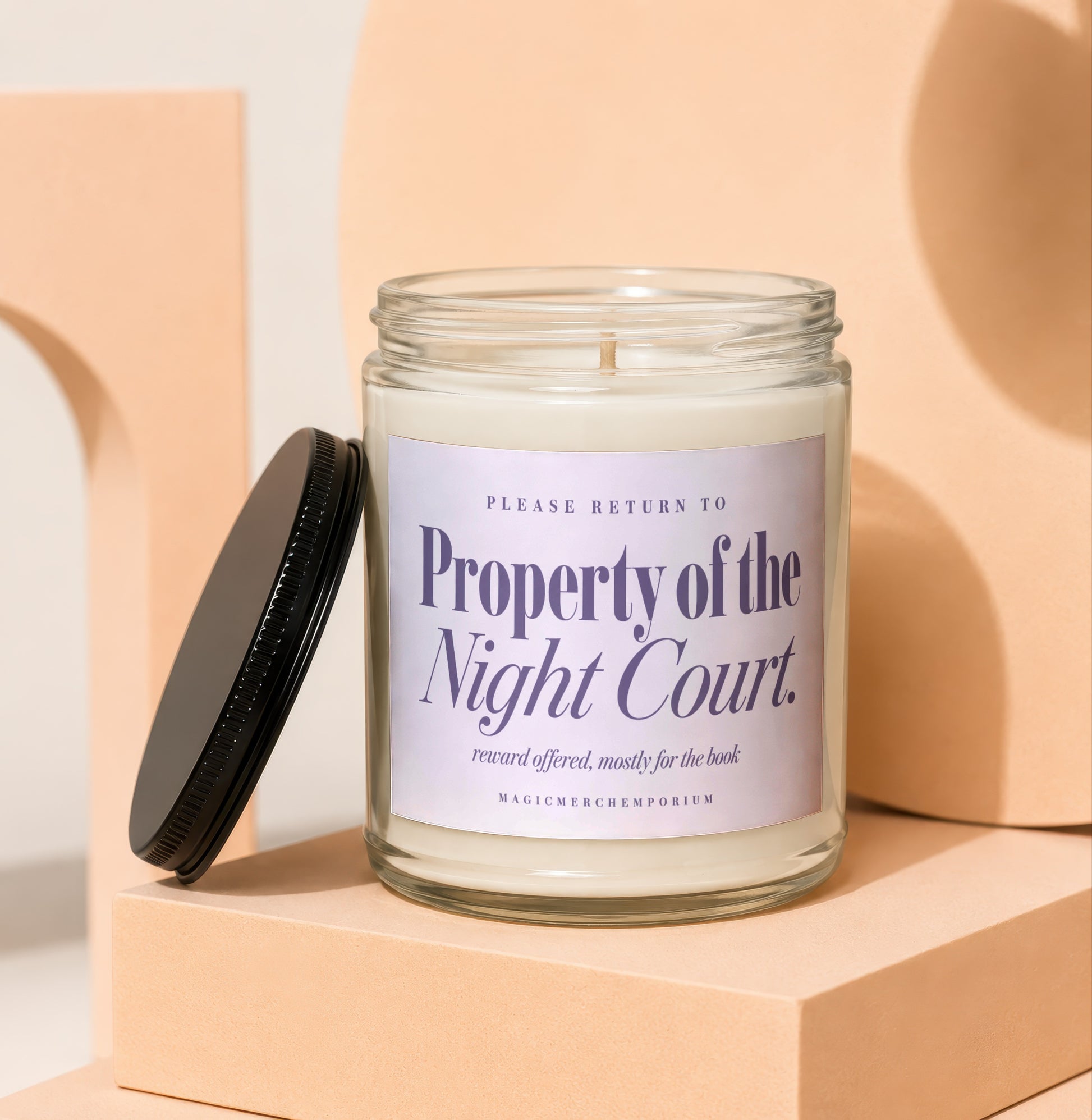 Glass candle with label reading "Property of the Night Court" and "MAGICMERCHEMPORIUM."