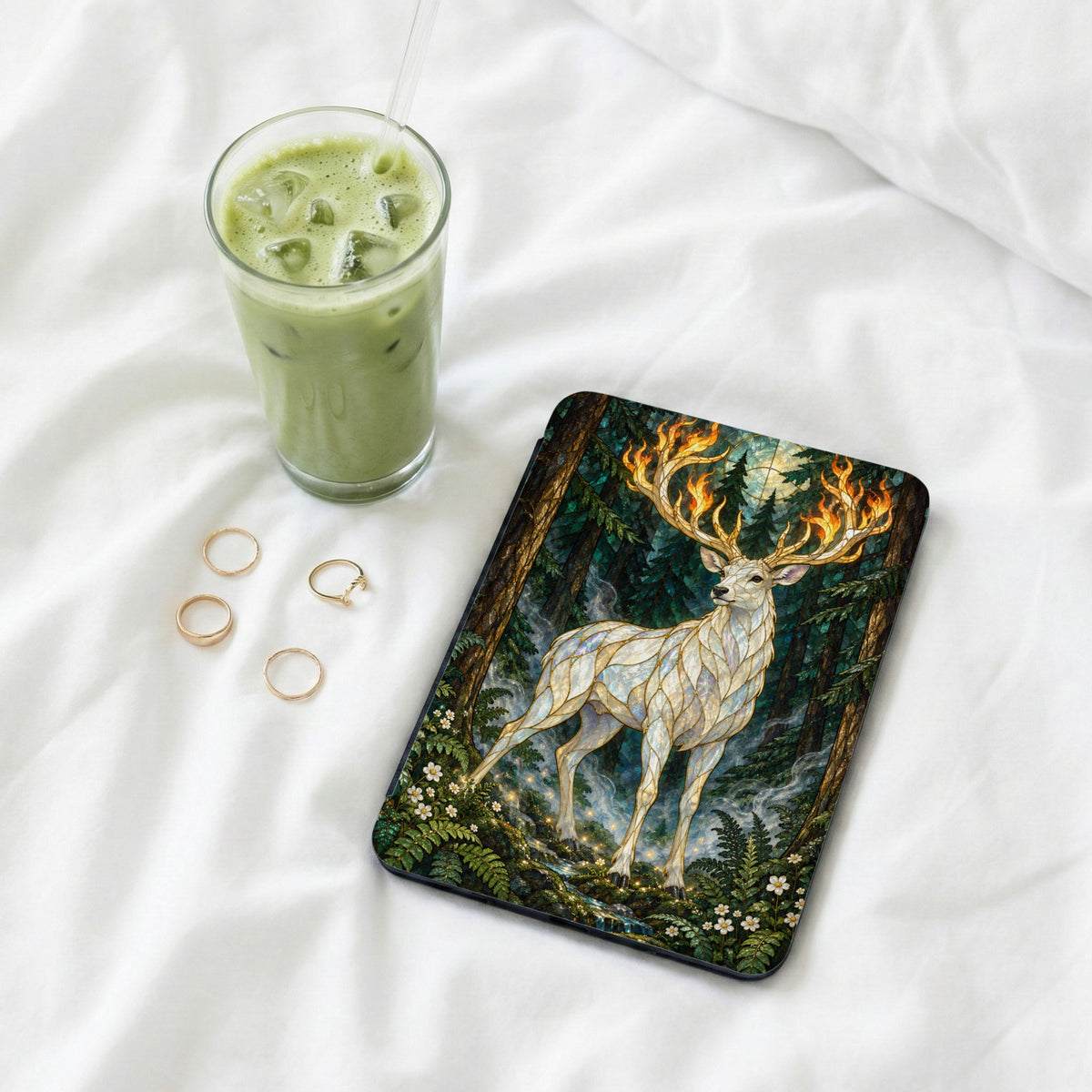 White stag with fiery antlers in a forest scene on a tablet cover.