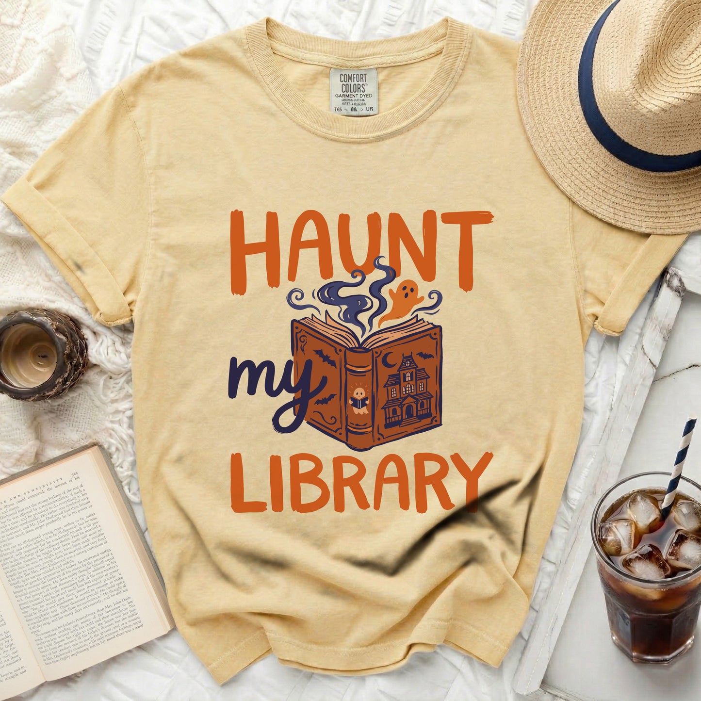 Yellow t-shirt with "Haunt my Library" text and book graphic.