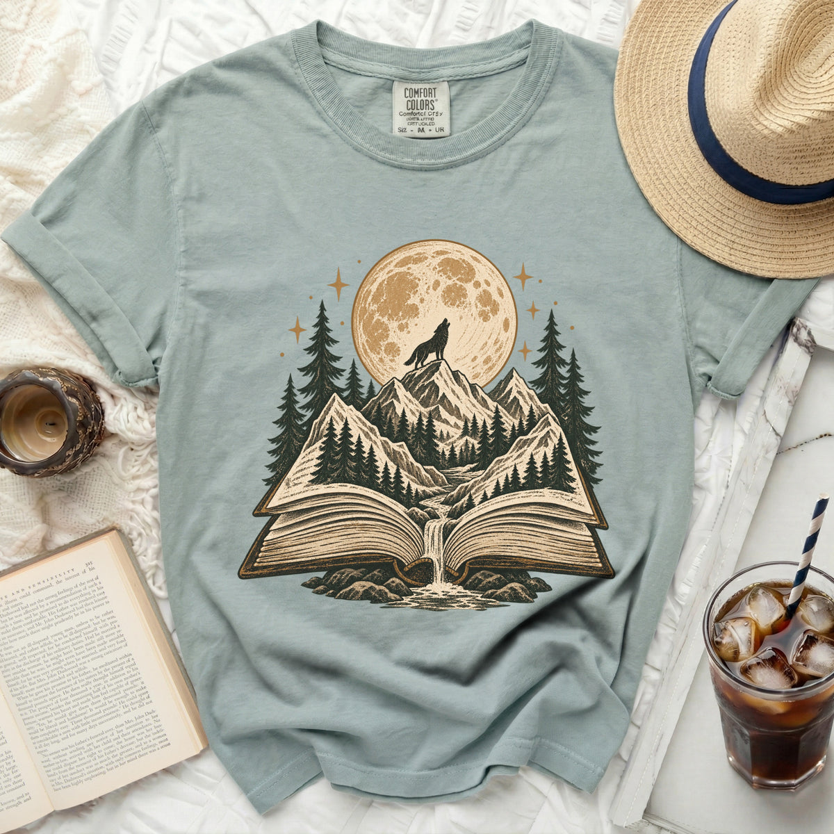 Open book with wolf on mountain under full moon and starry sky.