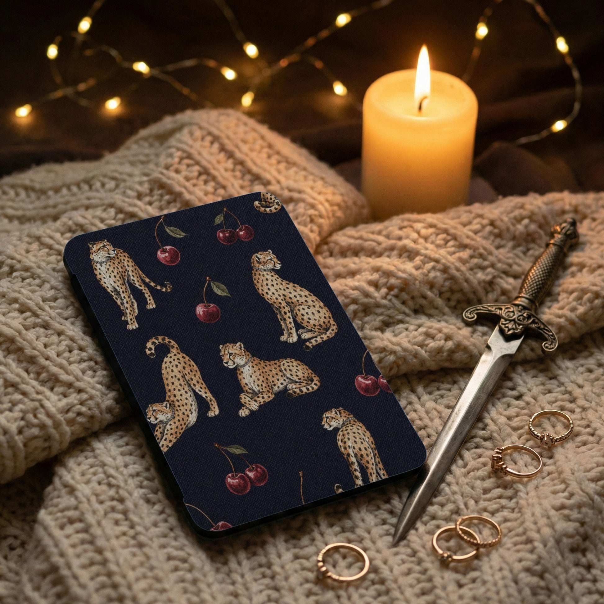 Dark blue case with cheetahs and cherries design on knitted fabric.