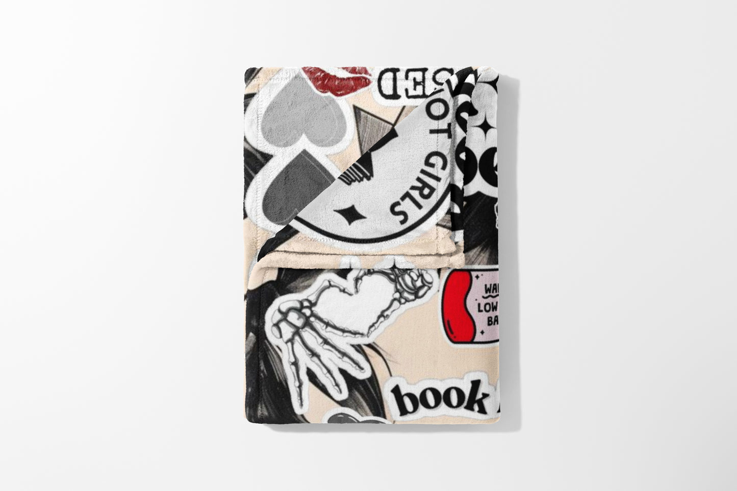 Folded blanket with a collage of stickers including hearts, lips, and text.