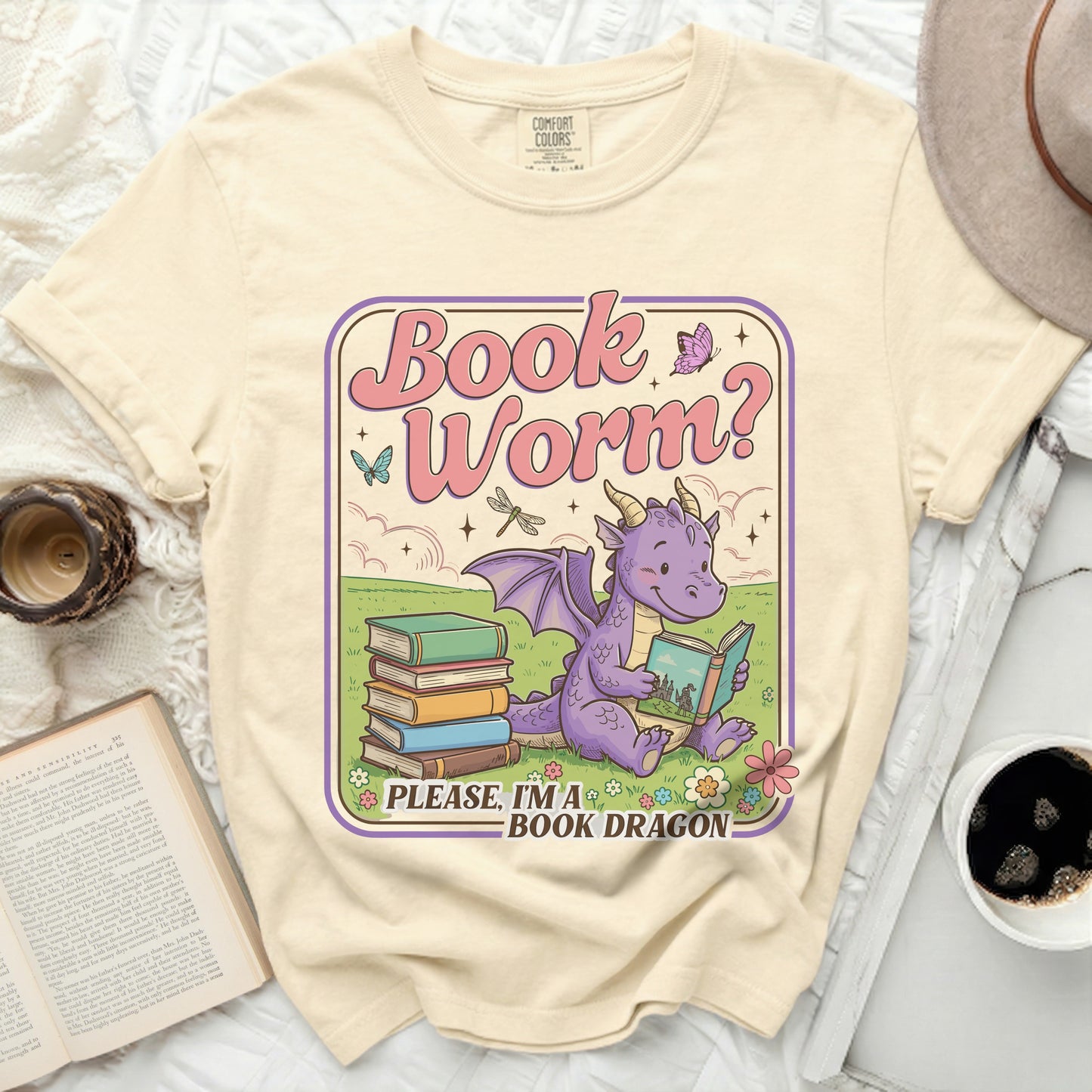 Cream t-shirt with a "Book Worm? Please, I'm a Book Dragon" graphic featuring a dragon reading a book.