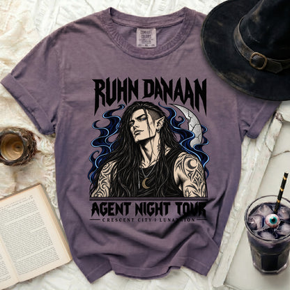 Purple t-shirt with "RUHN DANAAN AGENT NIGHT TOUR" and elf graphic.