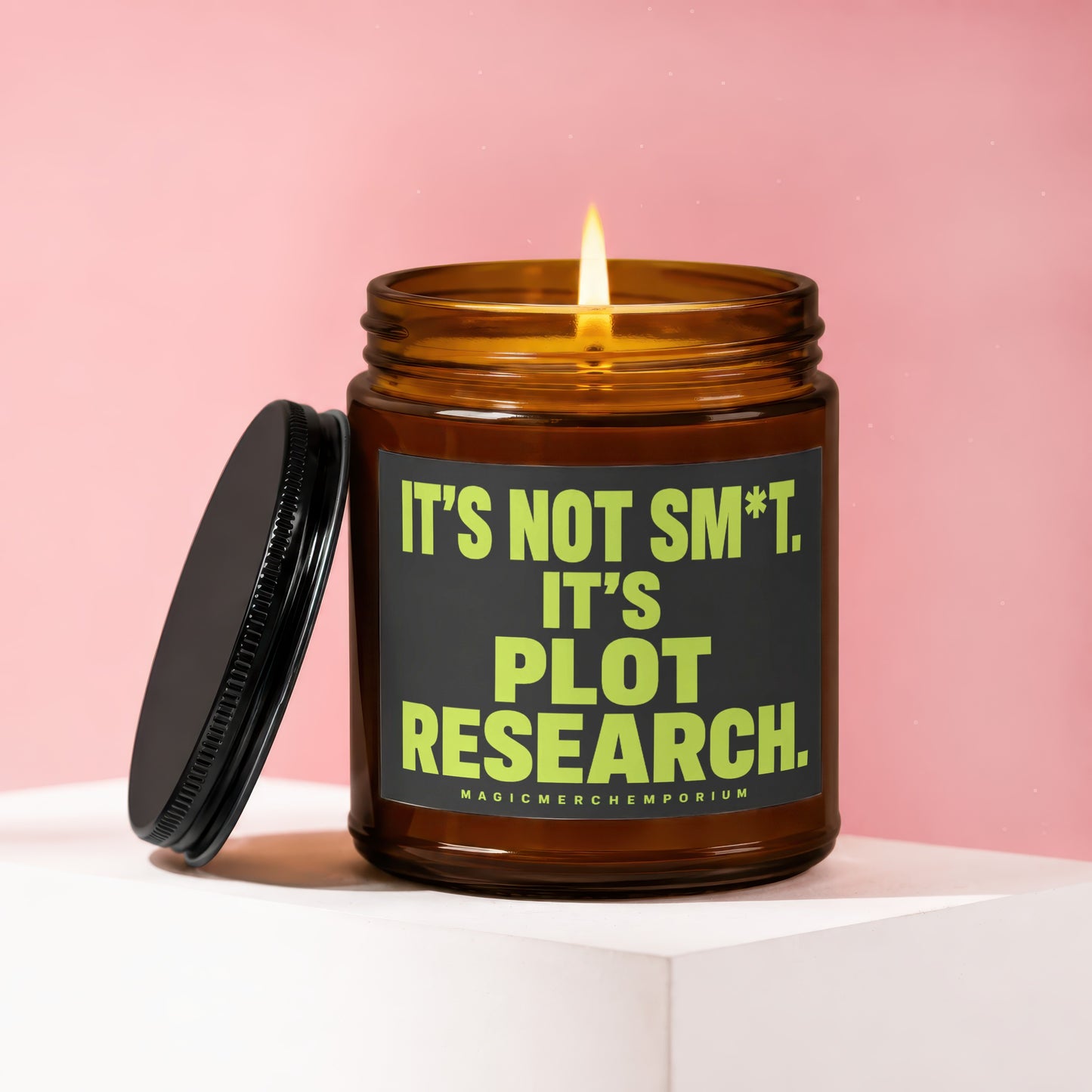 Amber candle with lit wick and black lid, text reads "It's not sm*t. It's plot research."