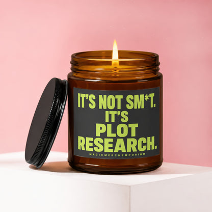 Amber candle with lit wick and black lid, text reads "It's not sm*t. It's plot research."