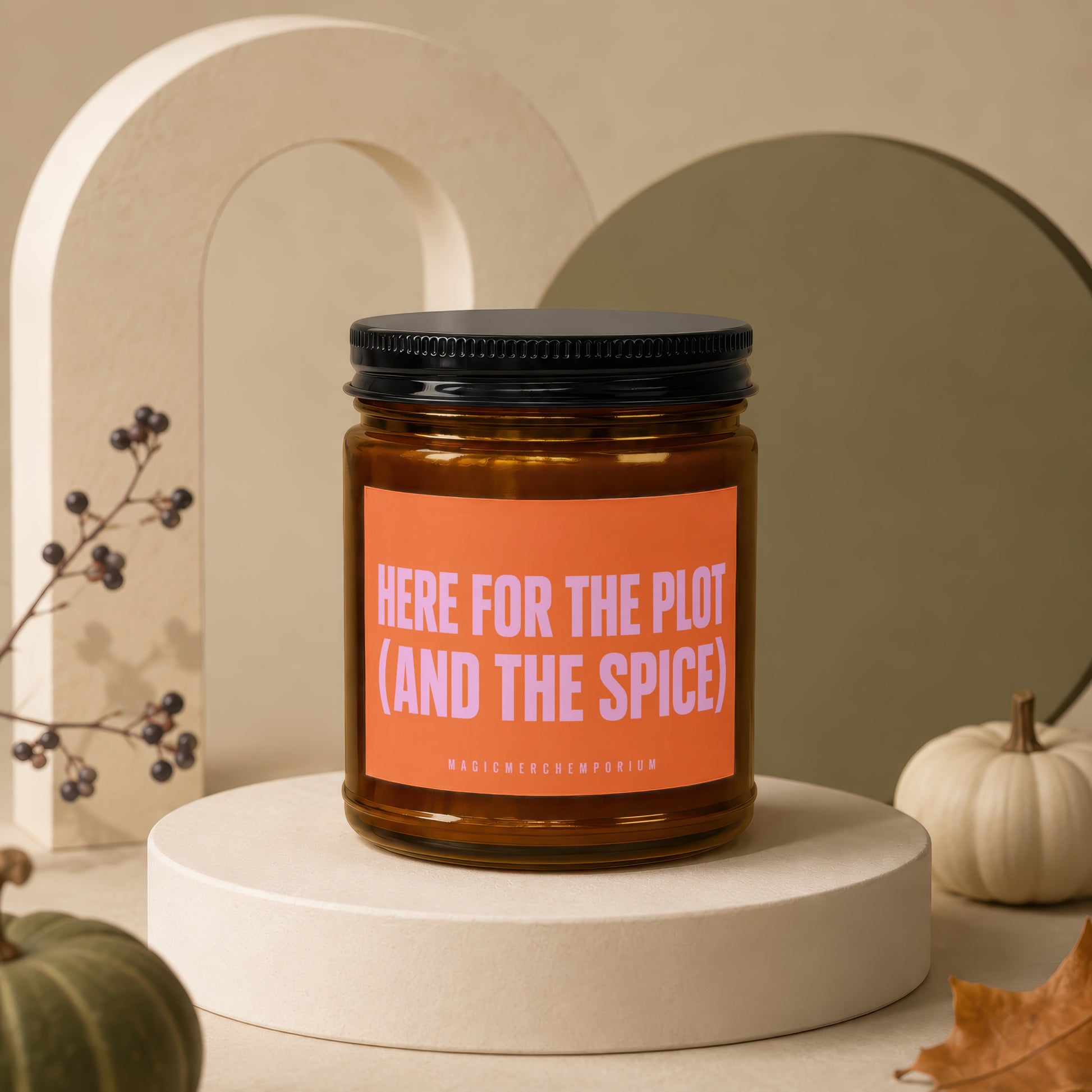 Amber jar candle with orange label reading "HERE FOR THE PLOT (AND THE SPICE)"