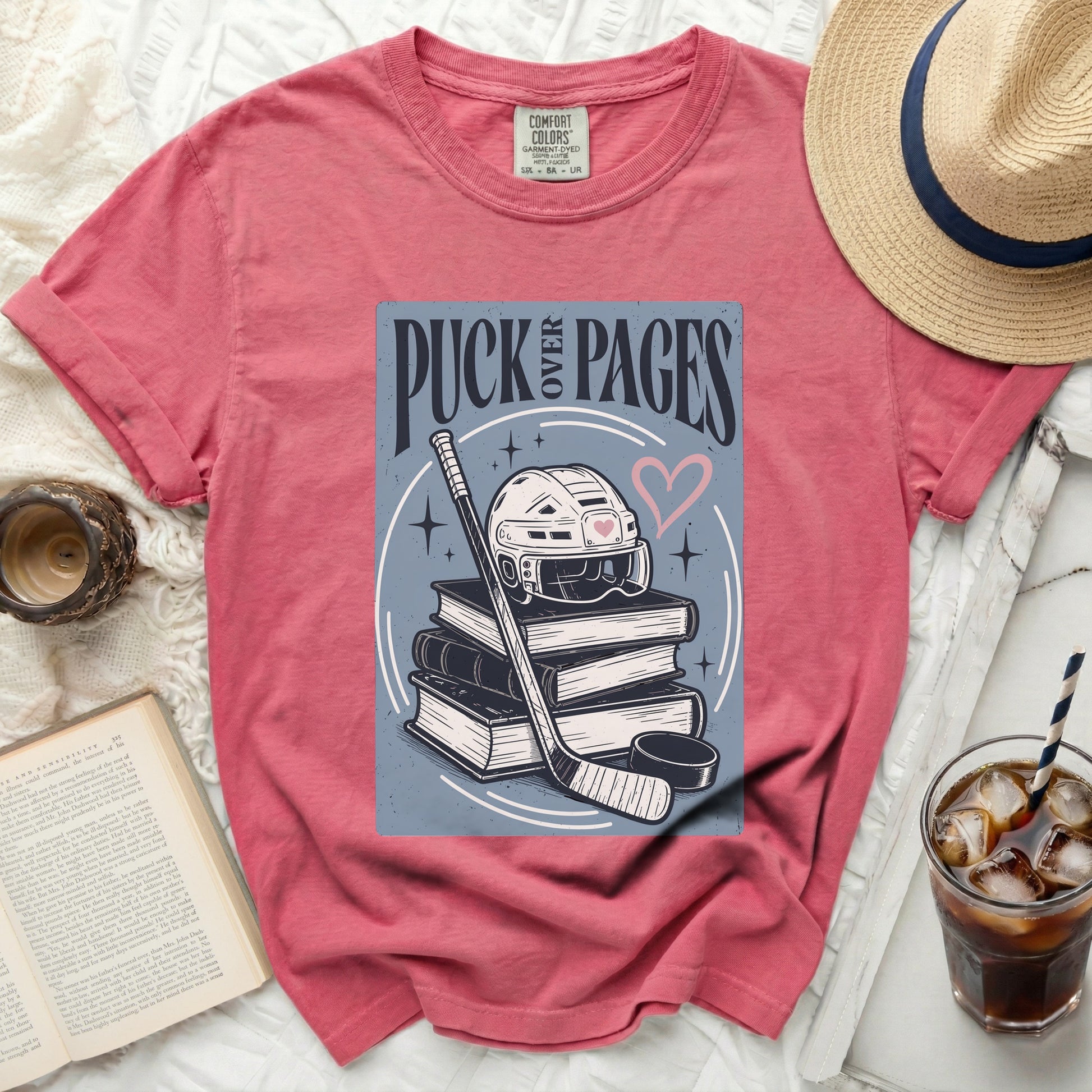 Pink t-shirt with puck, hockey stick, and books design.