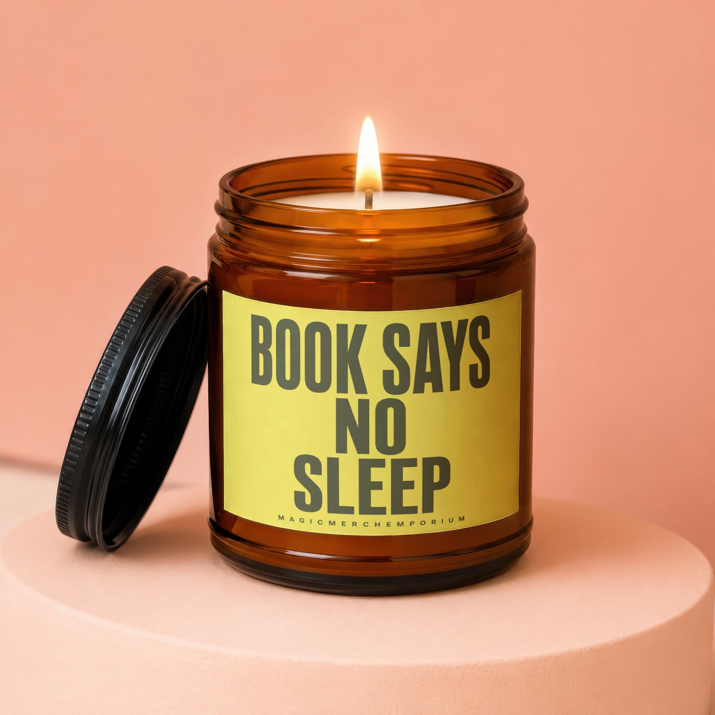 Amber jar candle with lit flame and a yellow label reading "BOOK SAYS NO SLEEP".