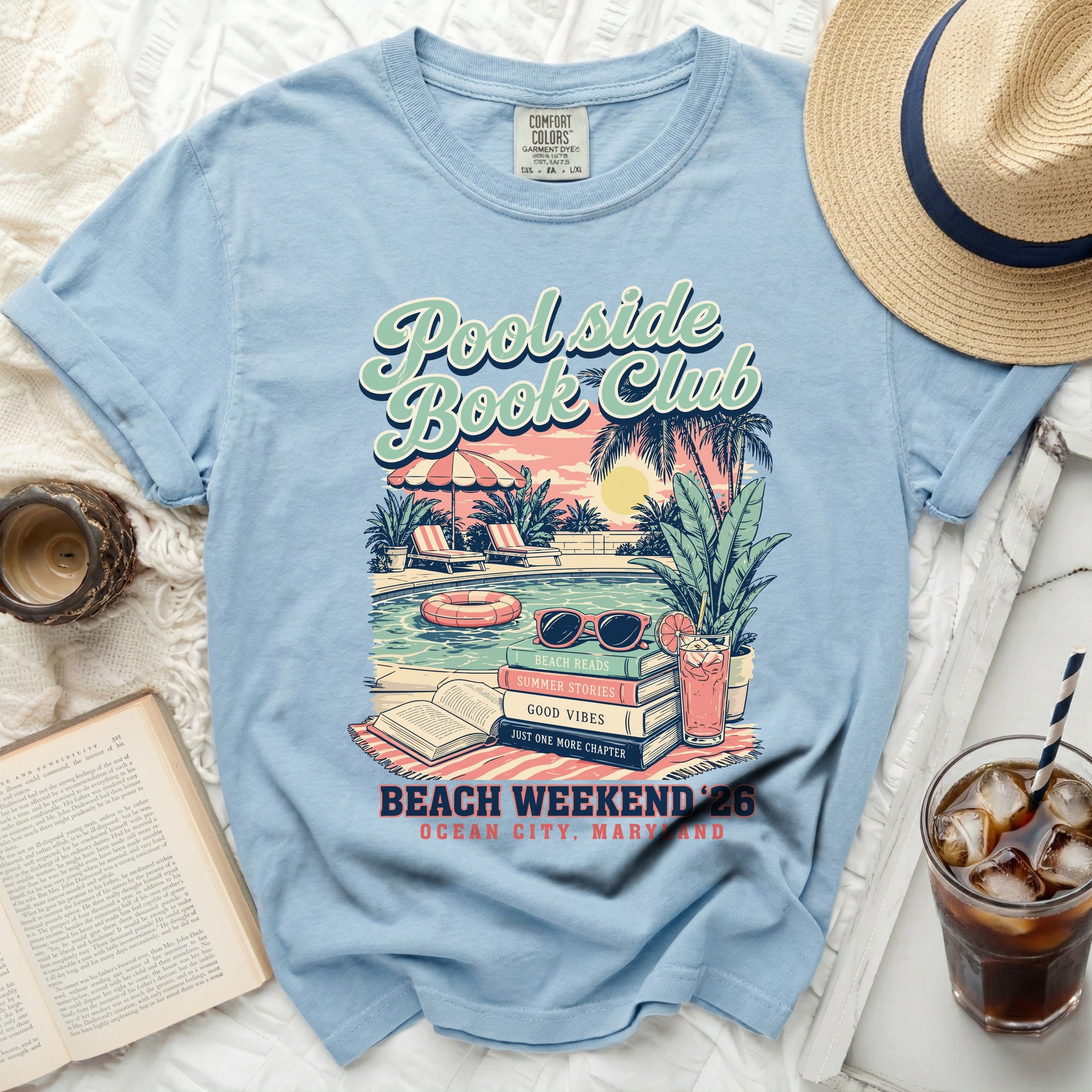 Light blue t-shirt with "Poolside Book Club" graphic and summery beach scene.