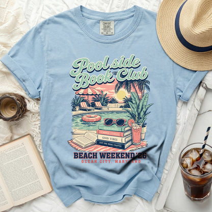 Light blue t-shirt with "Poolside Book Club" graphic and summery beach scene.